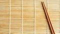 Chinese chopsticks on sushi mat background. Royalty Free Stock Photo
