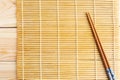 Chinese chopsticks on sushi mat background. Royalty Free Stock Photo