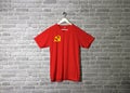 Chinese Communist Party flag on shirt and hanging on the wall with brick pattern wallpaper Royalty Free Stock Photo