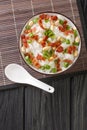 Chinese cooking, congee jook boiling rice with a lot of water over low heat with the addition of bacon, peanuts and onions close Royalty Free Stock Photo