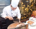 Chinese cooks in cutting roast pork