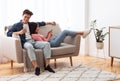 Chinese Couple Using Phones Relaxing Sitting On Sofa At Home Royalty Free Stock Photo