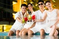 Chinese couples drinking cocktails in hotel pool bar Royalty Free Stock Photo