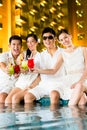 Chinese couples drinking cocktails in hotel pool bar Royalty Free Stock Photo