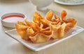 Chinese crab rangoon fried wontons on plate with red sauce