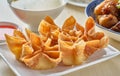 Chinese crab rangoon fried wontons on plate with red sauce