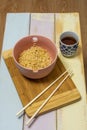 Chinese curly noodles cooked in a pink bowl with chopsticks Royalty Free Stock Photo