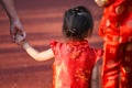 Chinese daugher hold mom hand with red cheongsam costume Royalty Free Stock Photo