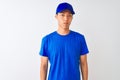 Chinese deliveryman wearing blue t-shirt and cap standing over isolated white background depressed and worry for distress, crying Royalty Free Stock Photo