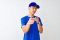 Chinese deliveryman wearing blue t-shirt and cap standing over isolated white background pointing fingers to camera with happy and