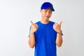 Chinese deliveryman wearing blue t-shirt and cap standing over isolated white background success sign doing positive gesture with