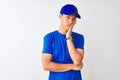 Chinese deliveryman wearing blue t-shirt and cap standing over isolated white background thinking looking tired and bored with