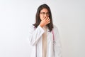 Chinese doctor woman wearing coat and pink stethoscope over isolated white background smelling something stinky and disgusting,