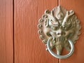 Chinese dragon head door knocker on wooden door.