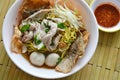 Chinese egg noodle with pork ball topping crispy fish skin in soup and chili sauce Royalty Free Stock Photo