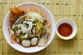 Chinese egg noodle with pork ball topping crispy fish skin in soup and chili sauce Royalty Free Stock Photo