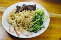 Chinese egg noodles topping slice barbecue pork and braised bone with dumping dressing sweet black sauce on plate Royalty Free Stock Photo