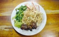 Chinese egg noodles topping slice barbecue pork and stew bone with dumping dressing sweet black sauce on plate Royalty Free Stock Photo