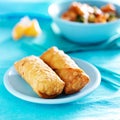 Chinese egg rolls on vibrant blue table setting Royalty Free Stock Photo