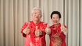 Chinese elderly senior couple in red costume thumb up gesture