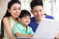 Chinese Family At Desk Using Laptop Royalty Free Stock Photo