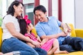 Chinese Family playing with daughter on sofa