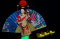 Chinese female doll in colourful costume with traditional gold ingots Royalty Free Stock Photo