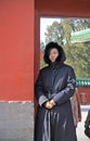 Chinese woman by the red wall in the temple