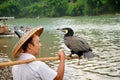 Chinese fisherman speaking with his fish eagle (ossifrage)