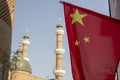 Chinese flag next to Uigher mosque with minarets, Urumchi, Xinjiang, China