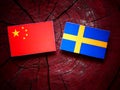 Chinese flag with Swedish flag on a tree stump Royalty Free Stock Photo