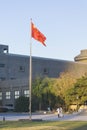 A Chinese flag in the unviersity called The Central Academy of Fine Arts CAFA,with two people walking under the flag Royalty Free Stock Photo