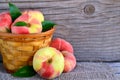 Chinese flat donut peaches in the basket on on old wooden table also known as Saturn donut, Doughnut peach, Paraguayo.Healthy eati Royalty Free Stock Photo