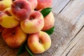 Chinese flat donut peaches with leaves on on old wooden table also known as Saturn donut, Doughnut peach, Paraguayo.Healthy eating