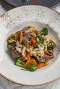 Chinese food beef noodles with broccoli, carrot, pepper and sesame seeds on the table Royalty Free Stock Photo