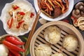 Chinese food on a gray wooden table. Traditional steam dumplings, noodles, vegetables, seafood. Royalty Free Stock Photo