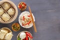 Chinese food on a gray wooden table. Traditional steam dumplings, noodles, vegetables, seafood. Royalty Free Stock Photo