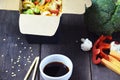 Chinese food, Noodles with pork and vegetables in take-out box on wooden table Royalty Free Stock Photo