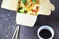 Chinese food, Noodles with pork and vegetables in take-out box on wooden table Royalty Free Stock Photo