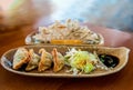 Chinese fried dumplings on a plate with soy sauce and vegetable salad close frame shoot indoor