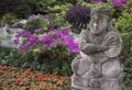 Chinese garden statue in front of flowers Royalty Free Stock Photo