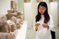 Chinese girl with interest using guidebook at ancient sculptures