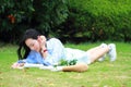 Chinese Girl reading the book. Blonde beautiful young woman with book lying on the grass. Royalty Free Stock Photo