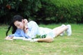 Chinese Girl reading the book. Blonde beautiful young woman with book lying on the grass. Royalty Free Stock Photo