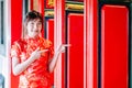 Chinese girl in traditional Chinese cheongsam pointing at china temple and introduce something to you