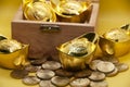 Chinese Gold Ingots and coins in treasure chest on yellow background. Wealth and prosperity concept.