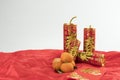 Chinese golden firecrackers and oranges on red cloth. Royalty Free Stock Photo