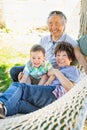 Chinese Grandparents In Hammock with Mixed Race Baby