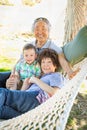 Chinese Grandparents In Hammock with Mixed Race Child