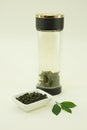 Chinese green tea. Milk Oolong Tea is brewed in a double glass thermo dish. Lemon leaf. Isolated in a white bowl on a white